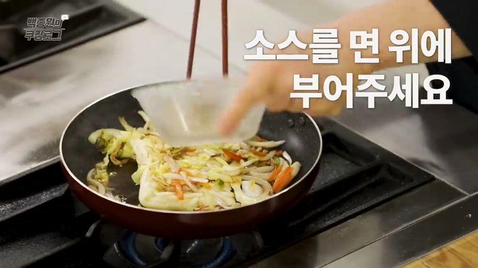 면 위에 양념장을 붓는 장면