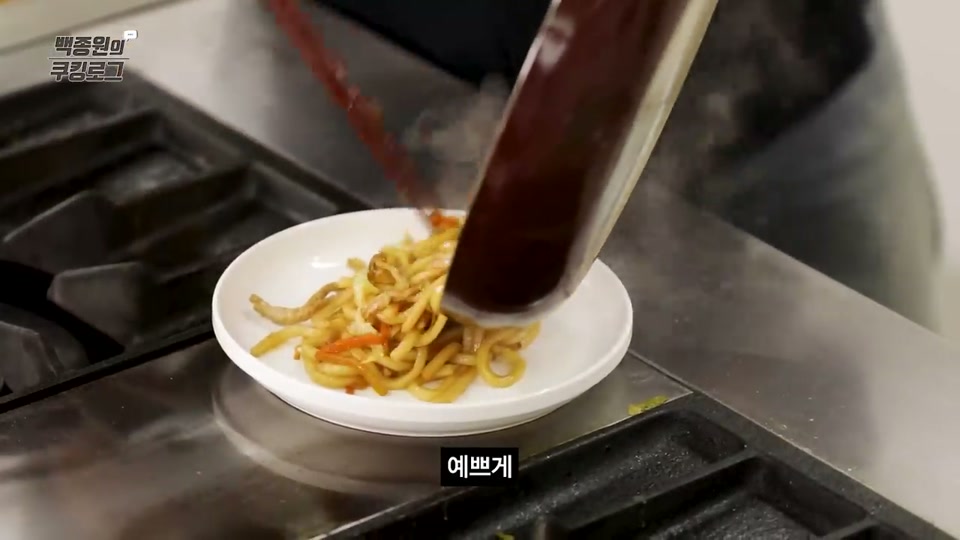그릇에 볶음우동을 담는 장면