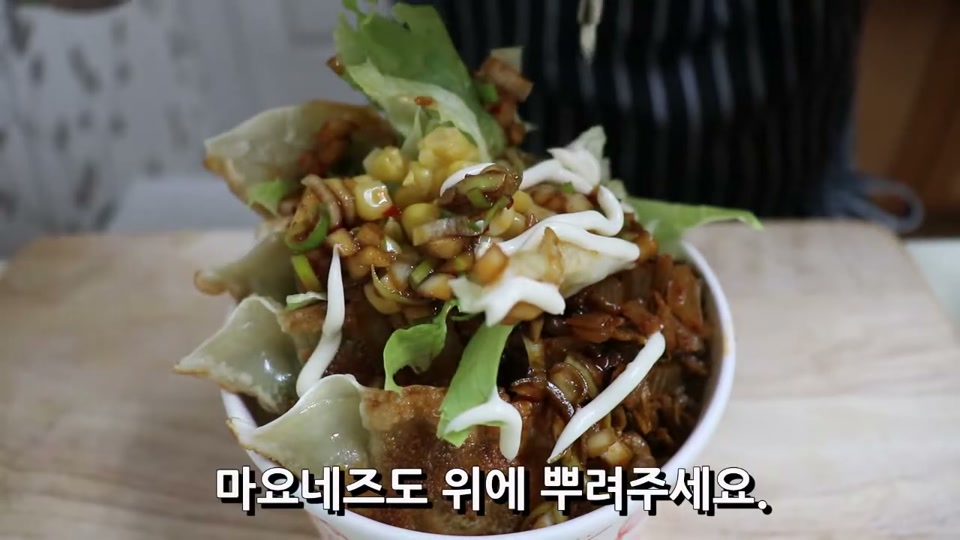 완성된 컵밥 위에 마요네즈를 뿌리는 장면