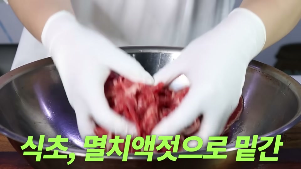 소불고기에 식초, 멸치액젓을 넣어 밑간하는 장면