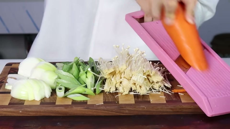 당근을 채칼로 써는 장면과 손질한 양파, 대파, 팽이버섯