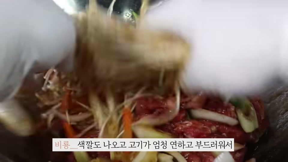 소불고기에 채소와 양념장을 넣고 버무리는 장면