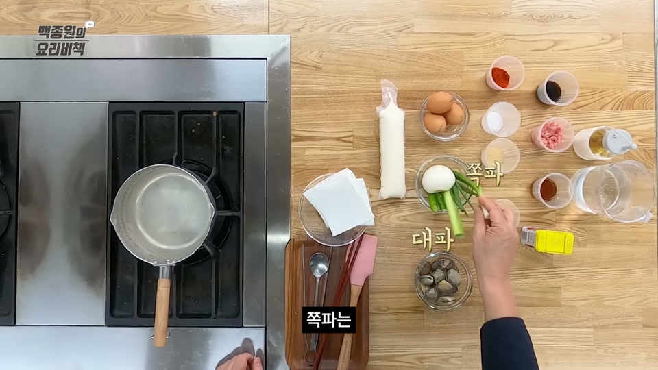 순두부, 계란, 바지락, 양념류를 늘어놓고 손질하는 모습