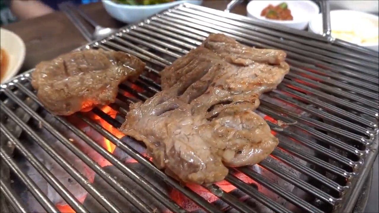 숯불 석쇠 위에서 구워지는 돼지갈비예요. 불향이 느껴질 것 같아요.